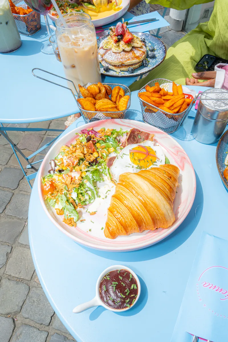 Assiette de croissant salé, œuf au plat et salade, vue du dessus sur une table de la terrasse